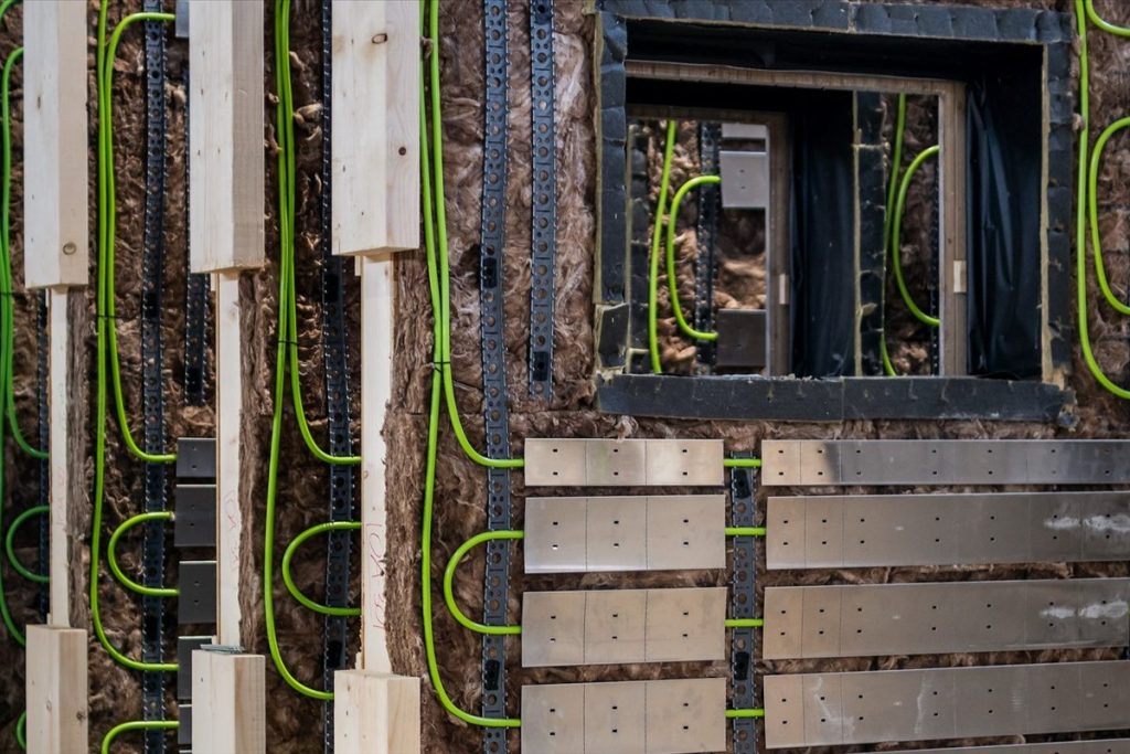 Vorgefertigte CEPA-Energiefassadenmodule mit Daemmung, Rohrleitungen und Edelstahlblechen in der Werkhalle
